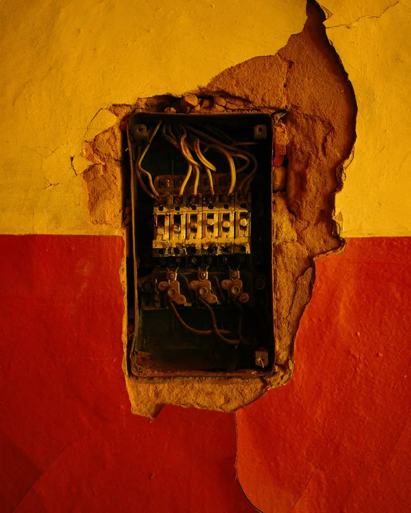 An old exposed electrical panel on a wall